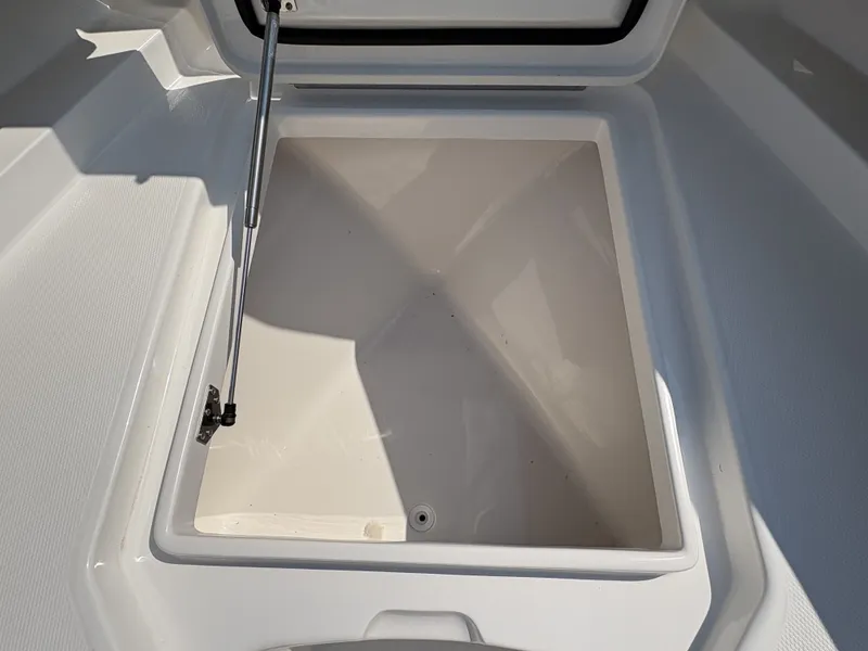 Slide: The Image of An open storage compartment on a 2025 Regulator 25 boat, featuring hydraulic support. - 42