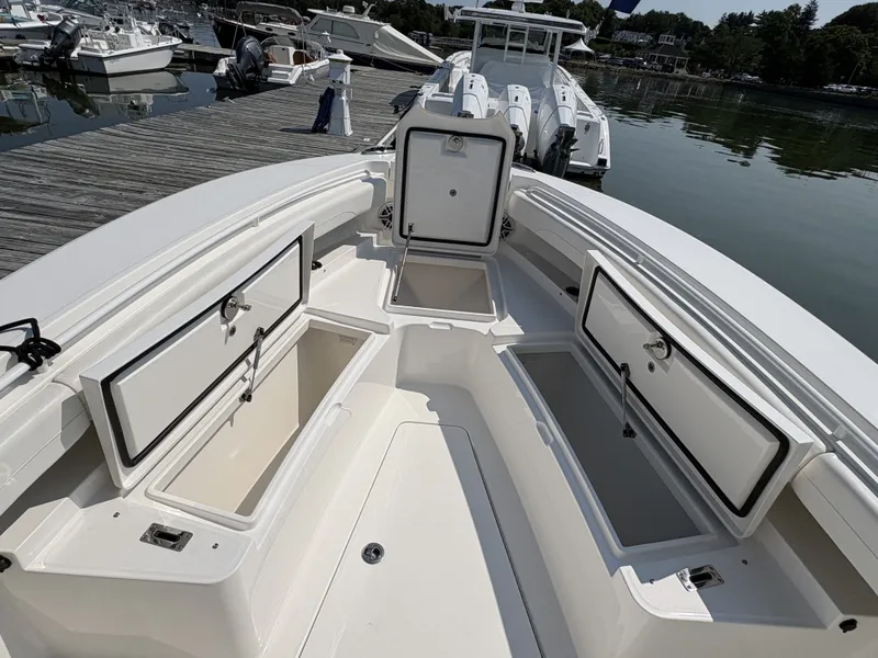 Slide: The Image of The image shows the deck of a Regulator 25 boat with several open storage compartments. - 39