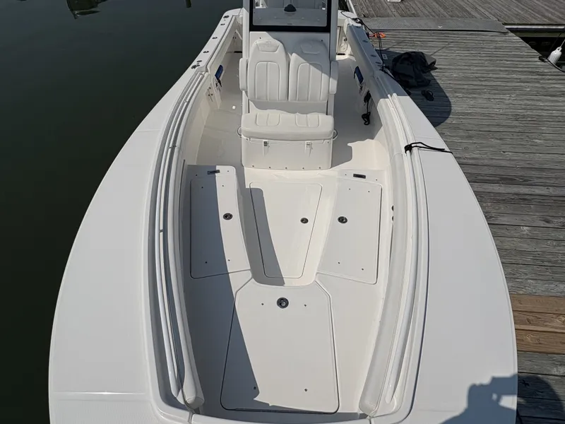 Slide: The Image of The image shows a modern boat with white seating and a spacious deck, docked at a pier. - 45