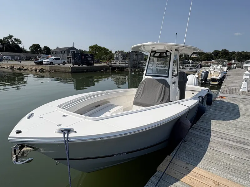 Slide: The Image of A 2025 Regulator 25 boat docked. It features a modern design and a protective cover. - 10