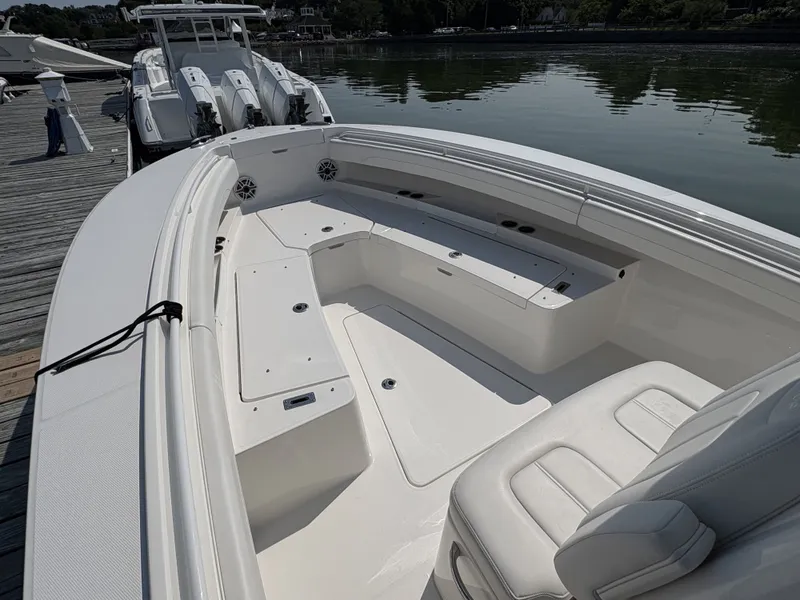 Slide: The Image of The image shows a modern boat with white upholstery and a spacious deck, docked at a pier. - 34