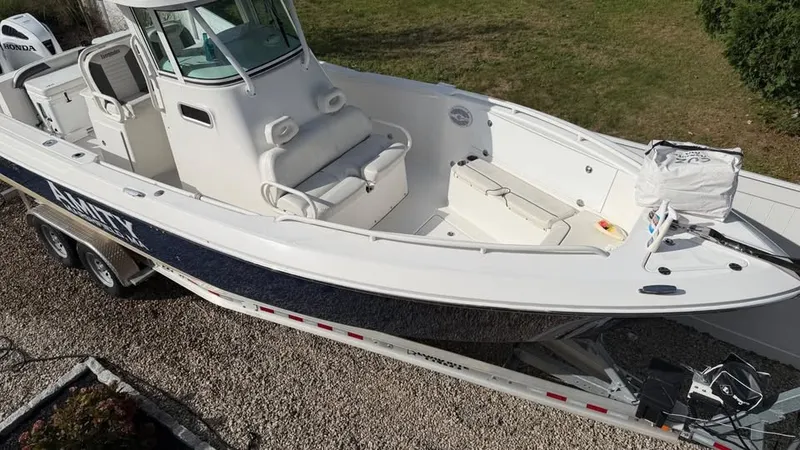 Slide: The Image of A 2007 Everglades 290 CC boat on a trailer. It features a spacious deck and cabin. - 3