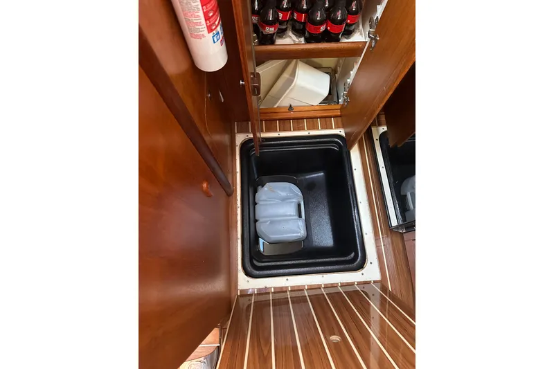 Slide: The Image of Storage compartment in 2007 Hunter 41 Deck Salon yacht with wooden flooring and beverage storage. - 16