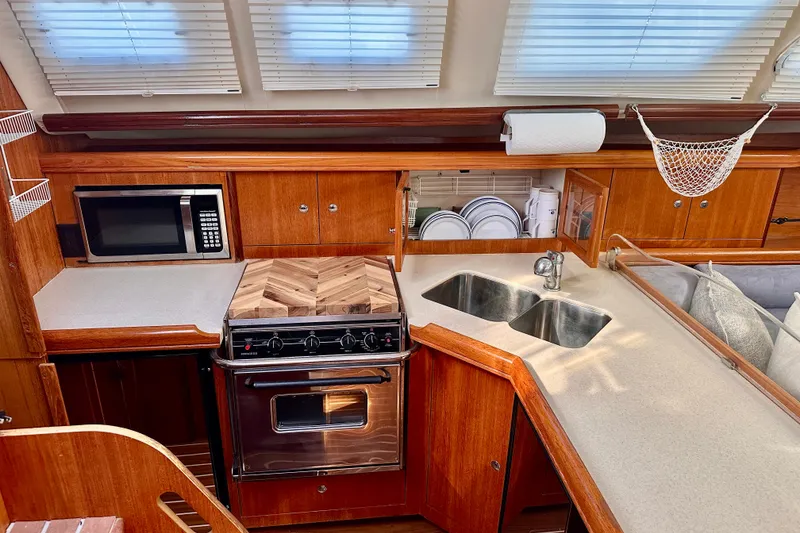 Slide: The Image of Luxurious 2007 Hunter 41 Deck Salon kitchen with wood cabinetry, stainless steel appliances, and dual sinks. - 9