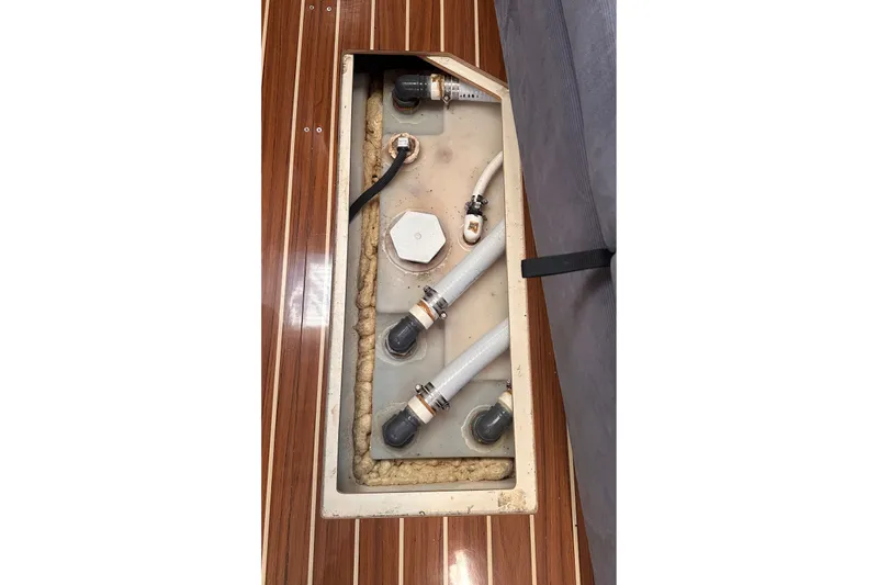 Slide: The Image of 2007 Hunter 41 Deck Salon boat interior showing plumbing system beneath wooden floor. - 14