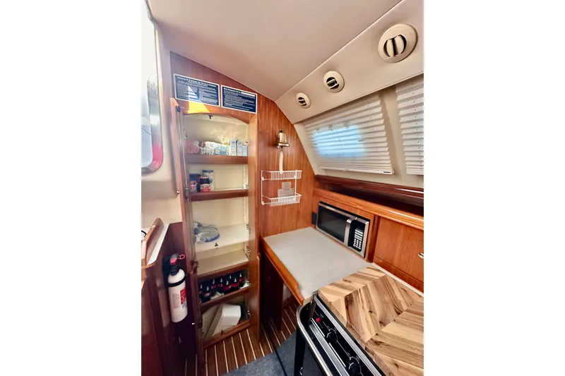 Slide: The Image of Interior of 2007 Hunter 41 Deck Salon yacht kitchen with wooden cabinetry and appliances. - 24