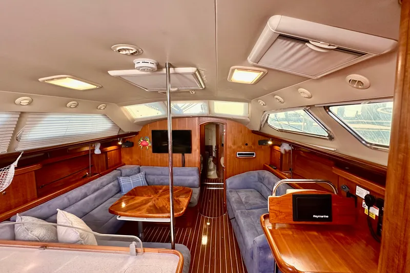 Slide: The Image of Interior of 2007 Hunter 41 Deck Salon yacht with elegant wood finish and plush seating. - 2