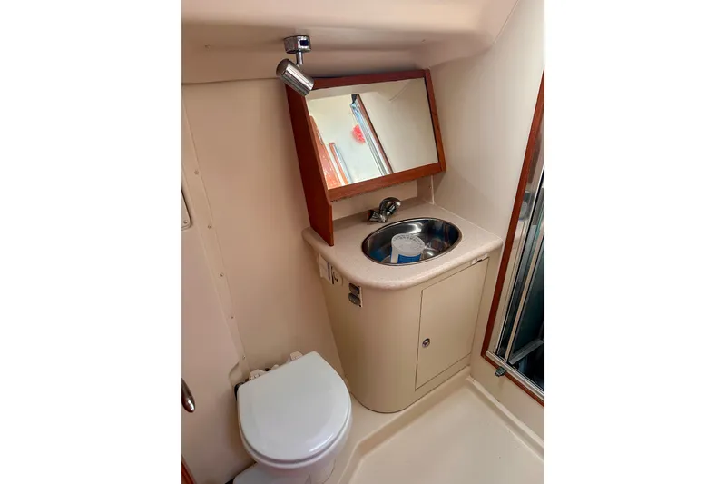 Slide: The Image of Compact bathroom in 2007 Hunter 41 Deck Salon yacht with sink, mirror, and toilet. - 12