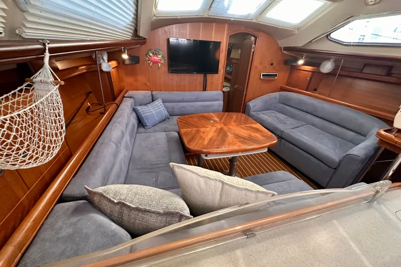 Slide: The Image of Interior of 2007 Hunter 41 Deck Salon with cozy seating and wooden table. - 3