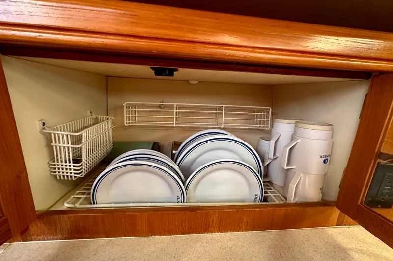 Slide: The Image of Cabinet with neatly organized plates and mugs in a 2007 Hunter 41 Deck Salon. - 21