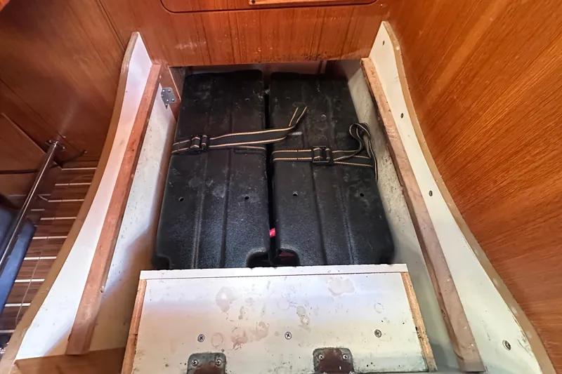 Slide: The Image of Storage compartment in 2007 Hunter 41 Deck Salon sailboat, featuring secured black containers. - 26