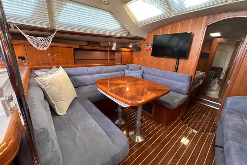 Slide: The Image of Interior of 2007 Hunter 41 Deck Salon with cozy seating and wooden table. - 29