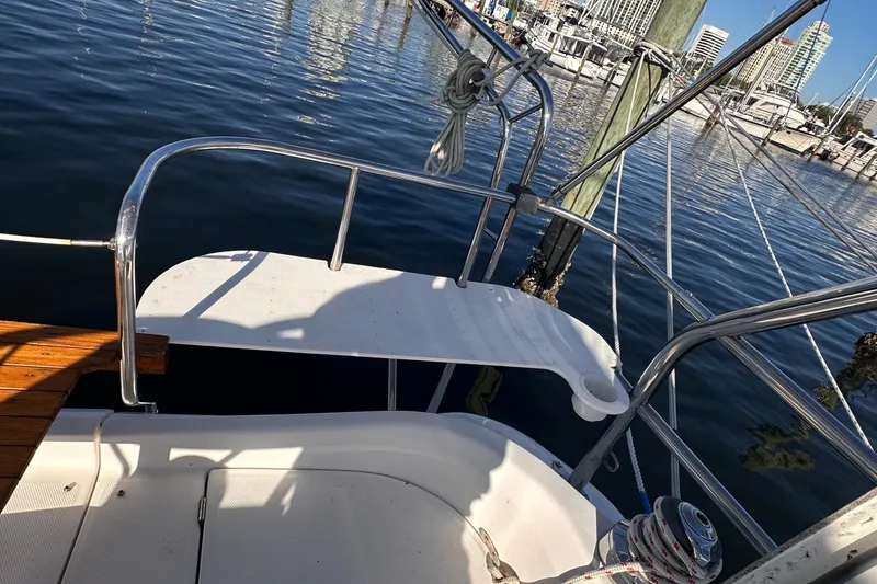 Slide: The Image of 2007 Hunter 41 Deck Salon yacht stern view at marina, showcasing railing and water reflections. - 37