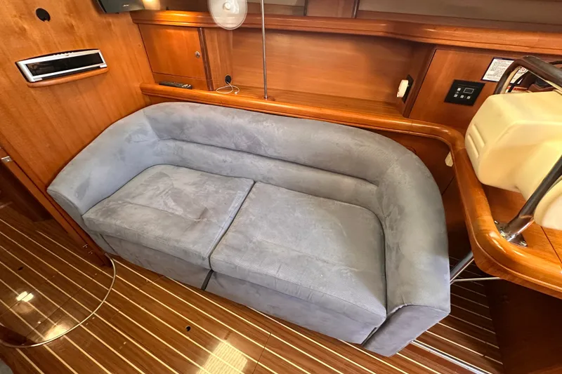Slide: The Image of Interior of 2007 Hunter 41 Deck Salon with blue sofa and wooden paneling. - 6