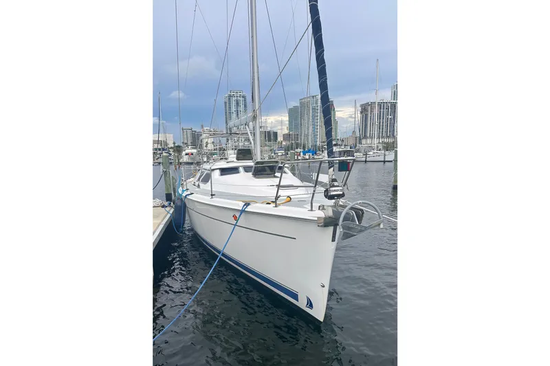 Slide: The Image of 2007 Hunter 41 Deck Salon sailboat docked in marina, city skyline in background. - 1