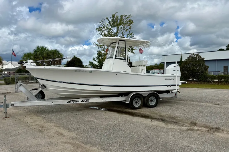 The Image of 2021 Regulator 24XO boat on trailer, parked outdoors under cloudy sky. - 0