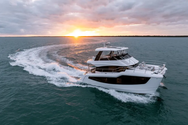 Slide: The Image of A modern Aquila 50 yacht cruises on the sea at sunset, leaving a white wake. - 10
