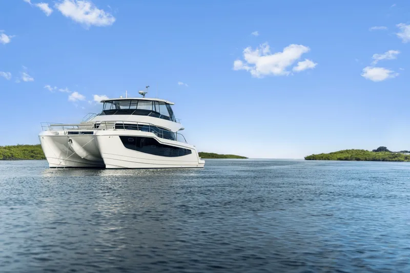 Slide: The Image of A modern Aquila 50 motor yacht cruising on calm waters under a blue sky. - 43