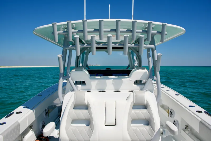 Slide: The Image of 2024 Freeman 38 boat on clear blue ocean, featuring sleek white seating and rod holders. - 19