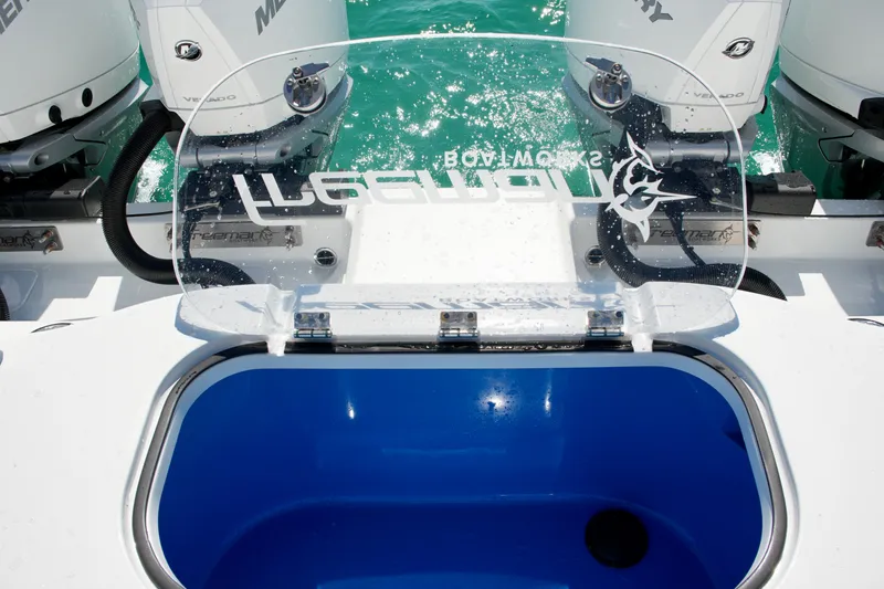 Slide: The Image of 2024 Freeman 38 boat with open livewell and Mercury engines in turquoise water. - 27