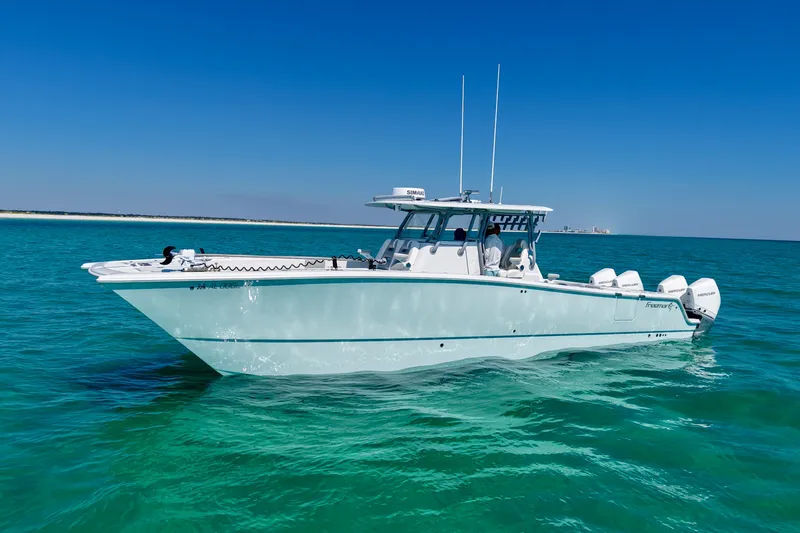 Slide: The Image of 2024 Freeman 38 boat cruising on clear turquoise waters under a bright blue sky. - 5