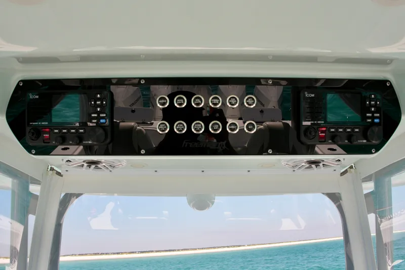 Slide: The Image of 2024 Freeman 38 boat dashboard with Icom radios and control panel, ocean view in background. - 14