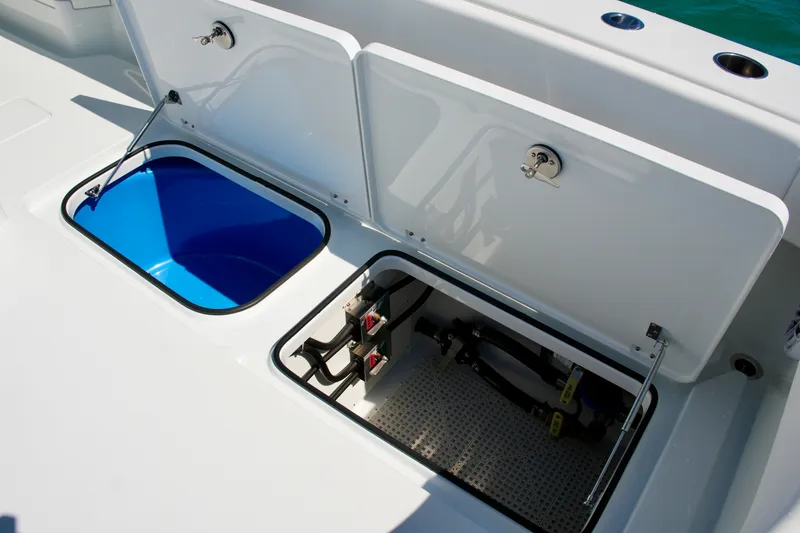 Slide: The Image of Open storage compartments on a 2024 Freeman 38 boat, featuring a blue interior and mechanical components. - 26