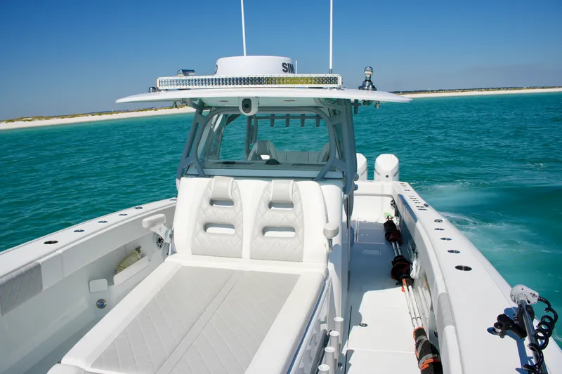 Slide: The Image of 2024 Freeman 38 boat cruising on turquoise waters near a sandy beach. - 32