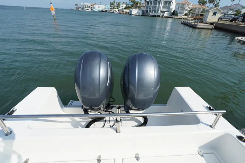 Slide: The Image of Twin outboard motors on a 2021 Cortez 31 Super Panga boat, docked near waterfront homes. - 25