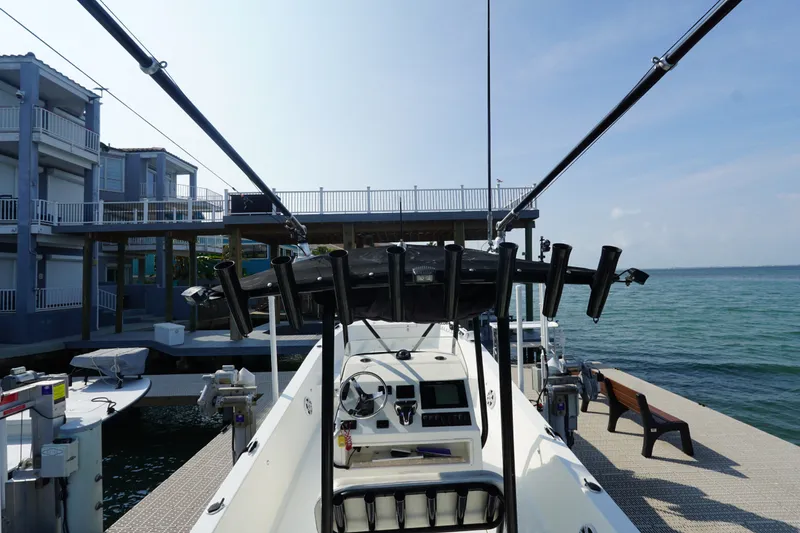 Slide: The Image of Cortez 31 Super Panga 2021 docked by waterfront homes, featuring fishing rod holders. - 6