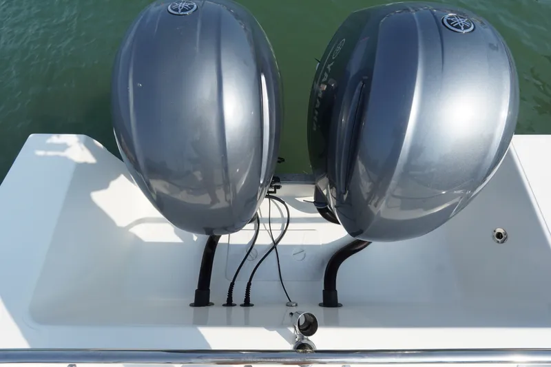 Slide: The Image of Twin outboard motors on a 2021 Cortez 31 Super Panga boat, docked on calm water. - 24