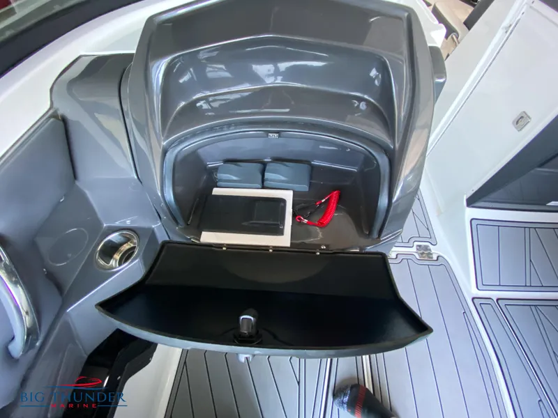 Slide: The Image of 2023 Monterey 298SS boat storage compartment with cup holder and accessories. - 28