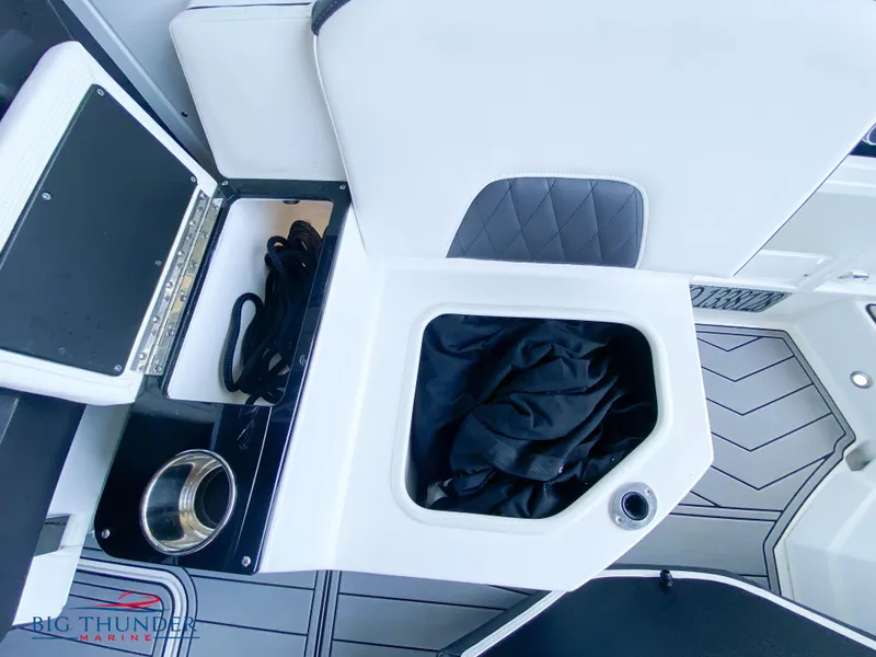 Slide: The Image of 2023 Monterey 298SS boat interior storage compartment with black fabric and cup holder. - 14