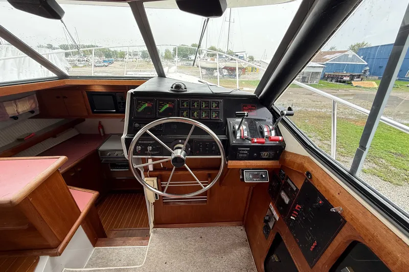 Slide: The Image of 1987 Bayliner 3270 Motoryacht helm with steering wheel, controls, and navigation instruments. - 22