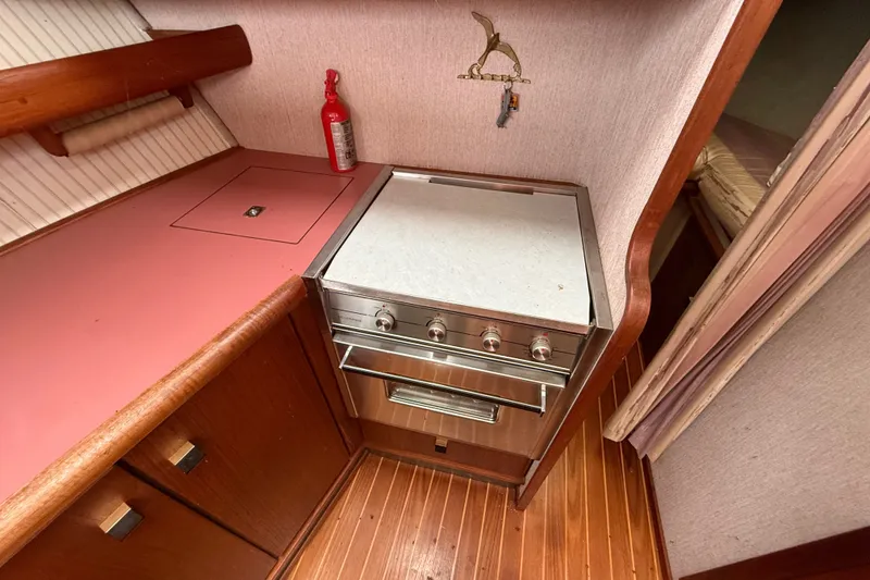 Slide: The Image of 1987 Bayliner 3270 Motoryacht kitchen with stove, wooden cabinets, and fire extinguisher. - 25