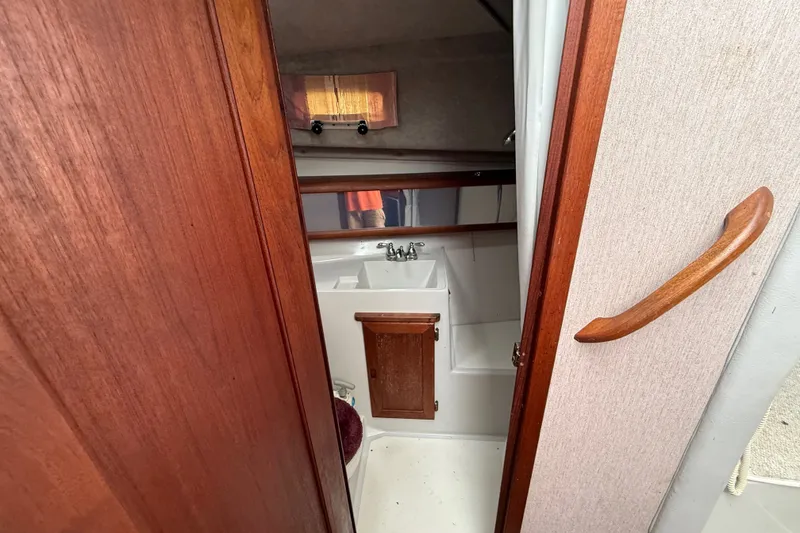 Slide: The Image of Interior view of 1987 Bayliner 3270 Motoryacht bathroom with wooden accents. - 27