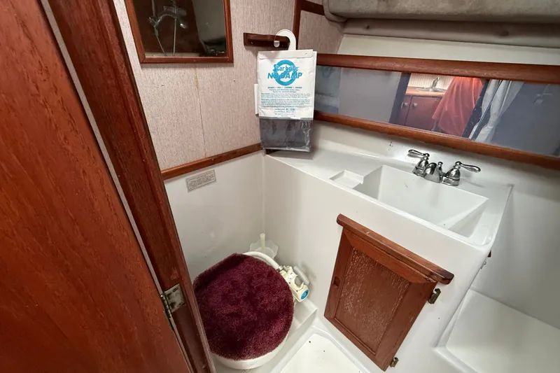 Slide: The Image of 1987 Bayliner 3270 Motoryacht bathroom with sink, toilet, and wooden cabinetry. - 28