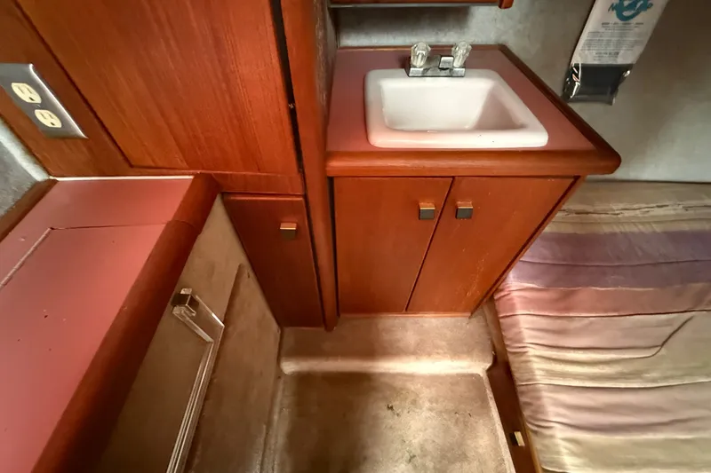 Slide: The Image of Interior of 1987 Bayliner 3270 Motoryacht with sink, wooden cabinets, and bed. - 34
