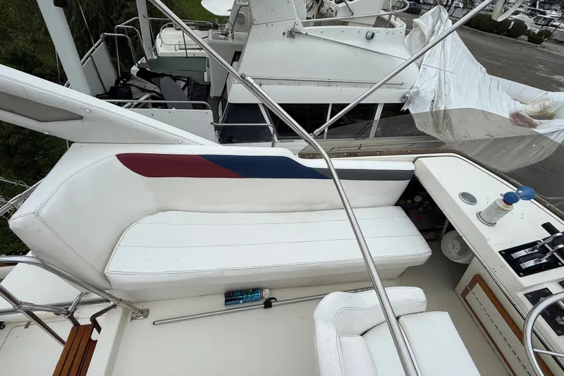 Slide: The Image of 1987 Bayliner 3270 Motoryacht cockpit with white seating and control panel. - 16