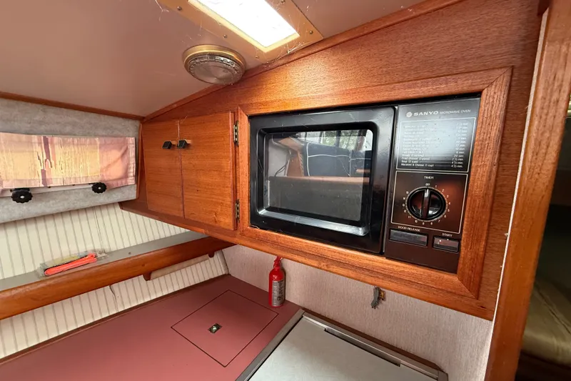 Slide: The Image of 1987 Bayliner 3270 Motoryacht interior with Sanyo microwave and wooden cabinetry. - 26