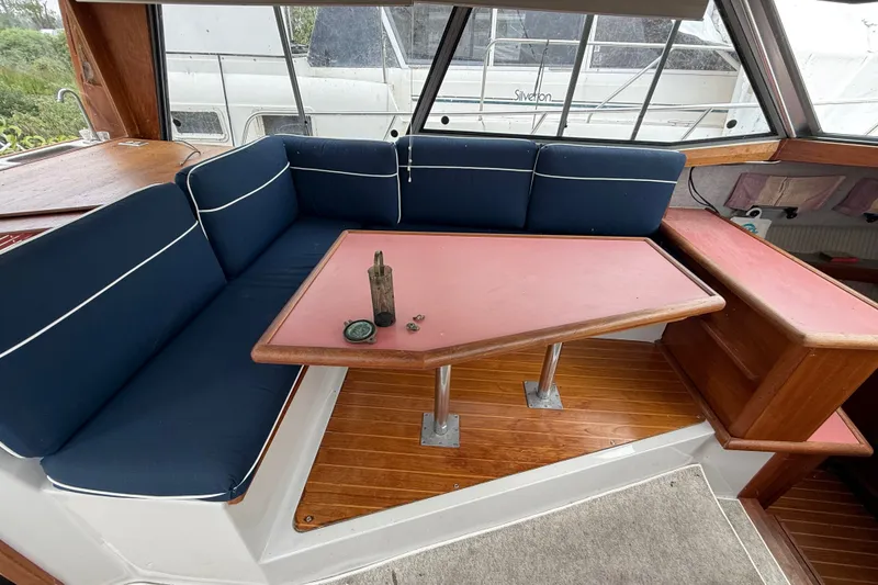 Slide: The Image of 1987 Bayliner 3270 Motoryacht interior with blue seating and wooden table. - 21