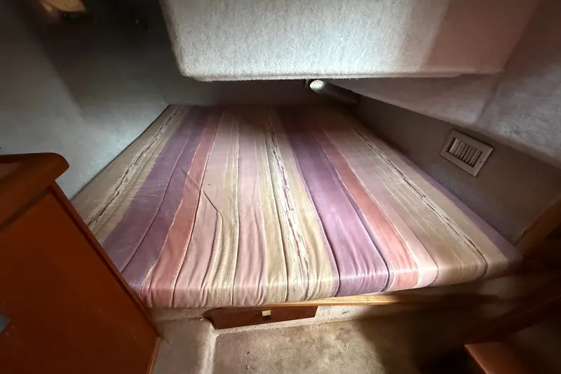 Slide: The Image of Cozy sleeping area in 1987 Bayliner 3270 Motoryacht with striped bedding. - 33