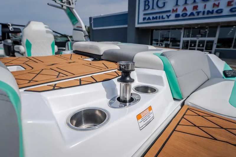 Slide: The Image of 2021 Tigé 21ZX boat interior with stylish seating and cup holders at a marine dealership. - 13