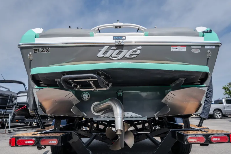 Slide: The Image of 2021 Tigé 21ZX boat rear view on trailer, showcasing propeller and hull design. - 3