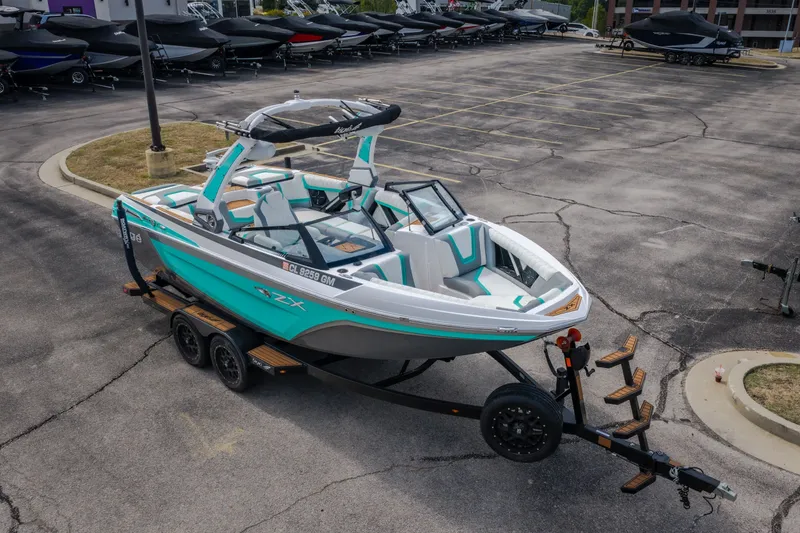 Slide: The Image of 2021 Tigé 21ZX boat on trailer in parking lot, showcasing sleek design and vibrant colors. - 44