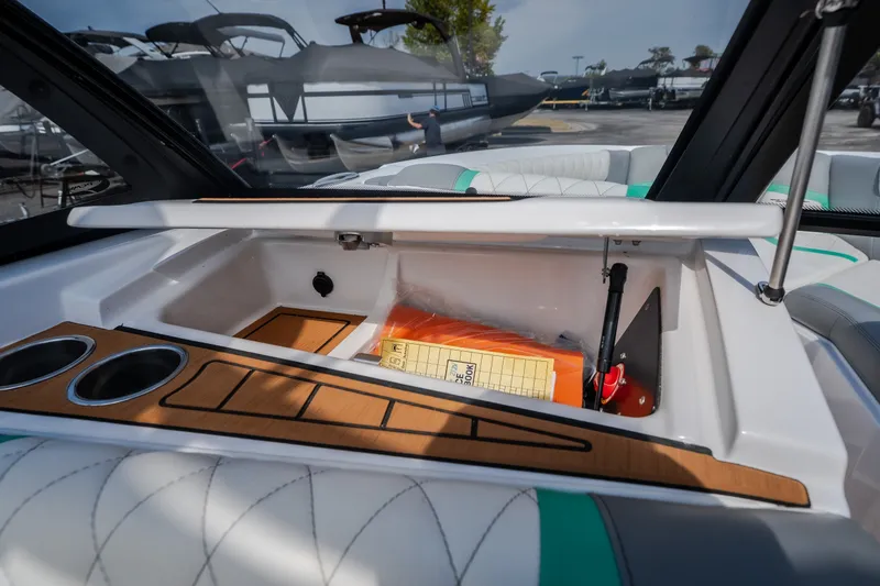 Slide: The Image of 2021 Tigé 21ZX boat interior storage compartment with cup holders and safety equipment. - 19