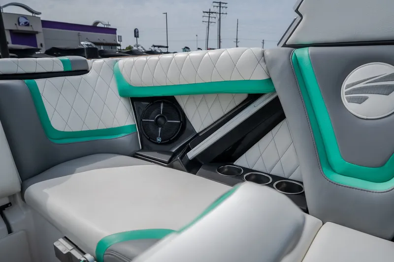 Slide: The Image of 2021 Tigé 21ZX boat interior with white and teal upholstery, featuring cup holders and speaker. - 39