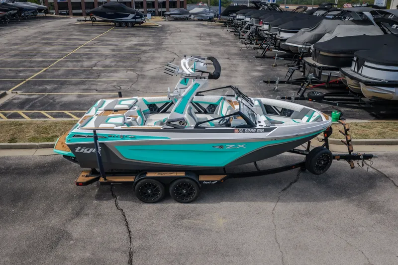 Slide: The Image of 2021 Tigé 21ZX boat in parking lot, vibrant teal and gray design, on trailer. - 43