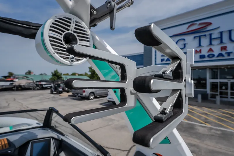 Slide: The Image of 2021 Tigé 21ZX boat with wakeboard rack and speaker, displayed at a dealership. - 18