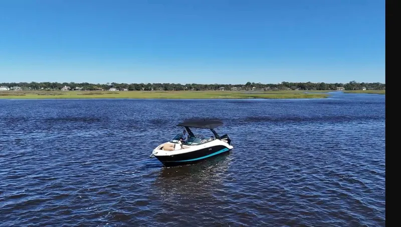 Slide: The Image of A 2027 Sea Ray SLX 260 Outboard on calm waters with a green shoreline in the background. - 16